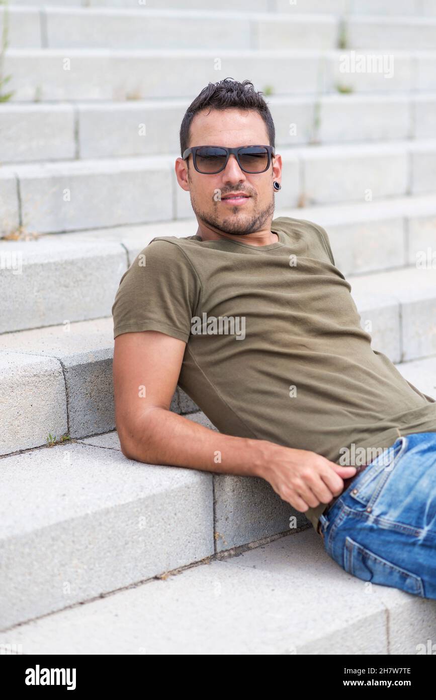 Man sitting alone on steps. Handsome boy with sunglasses Stock Photo ...