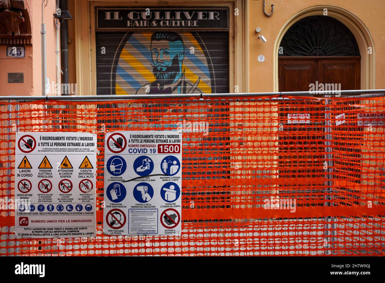 Construction site in Bologna. On the red barrier fence are the instructions of the Corona protection measures. Stock Photo