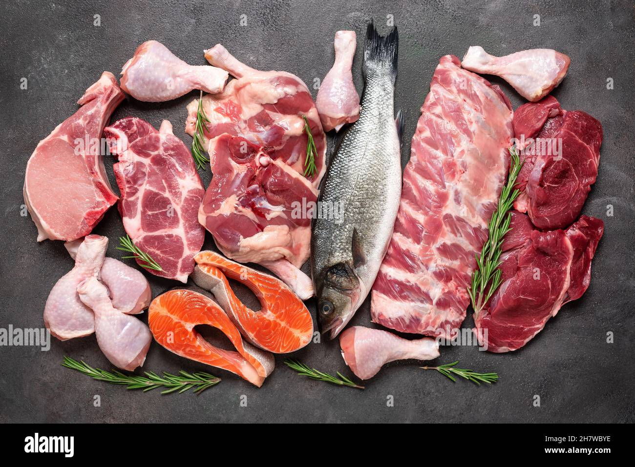 Set of various raw meats on a dark grunge background. Beef, pork, fish