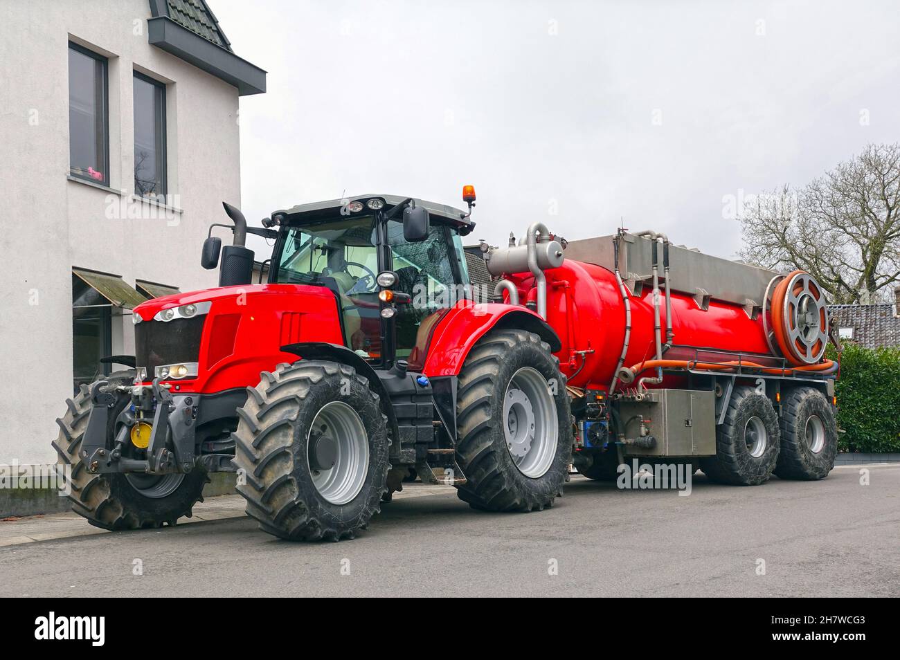 Tractor with sewerage trailer for septic work on a public road Stock Photo