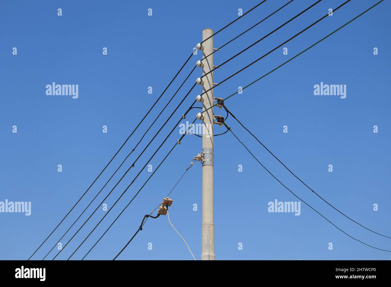 Five electrical cables on pole in Malta blue sky background Three