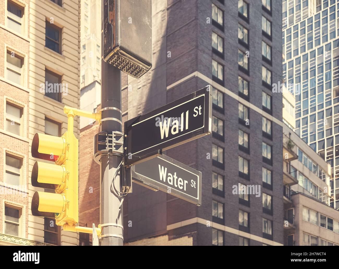 Traffic lights pole with Wall Street and Water Street in downtown New York, color toning applied, USA. Stock Photo