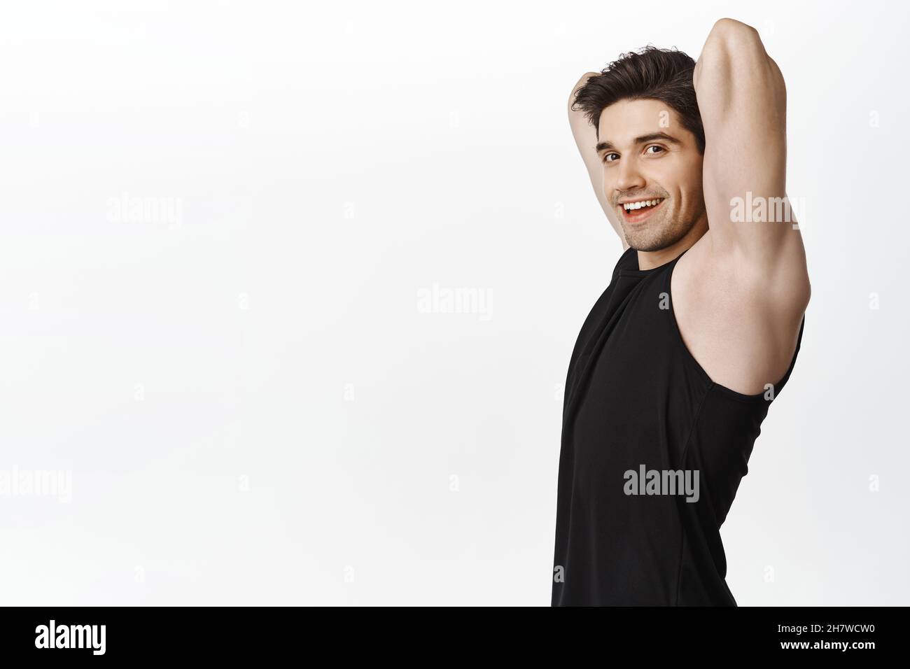 Profile portrait of male athlete, fitness guy stretching arms behind