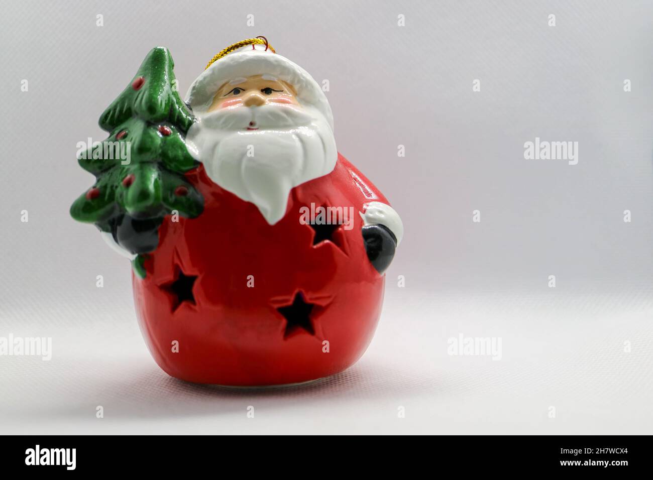 Santa Claus with red body, green Christmas tree, Santa Claus  ceramic figure on white background, Christmas  decoration, New Year card Stock Photo
