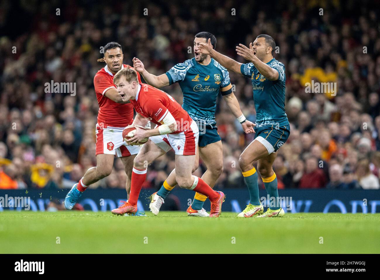 Kurtley Beale and Tom Wright appeal for a knock on by outside centre, Nick Tompkins, as he recovers the ball and scampers away to score a try under the posts for Wales. Stock Photo