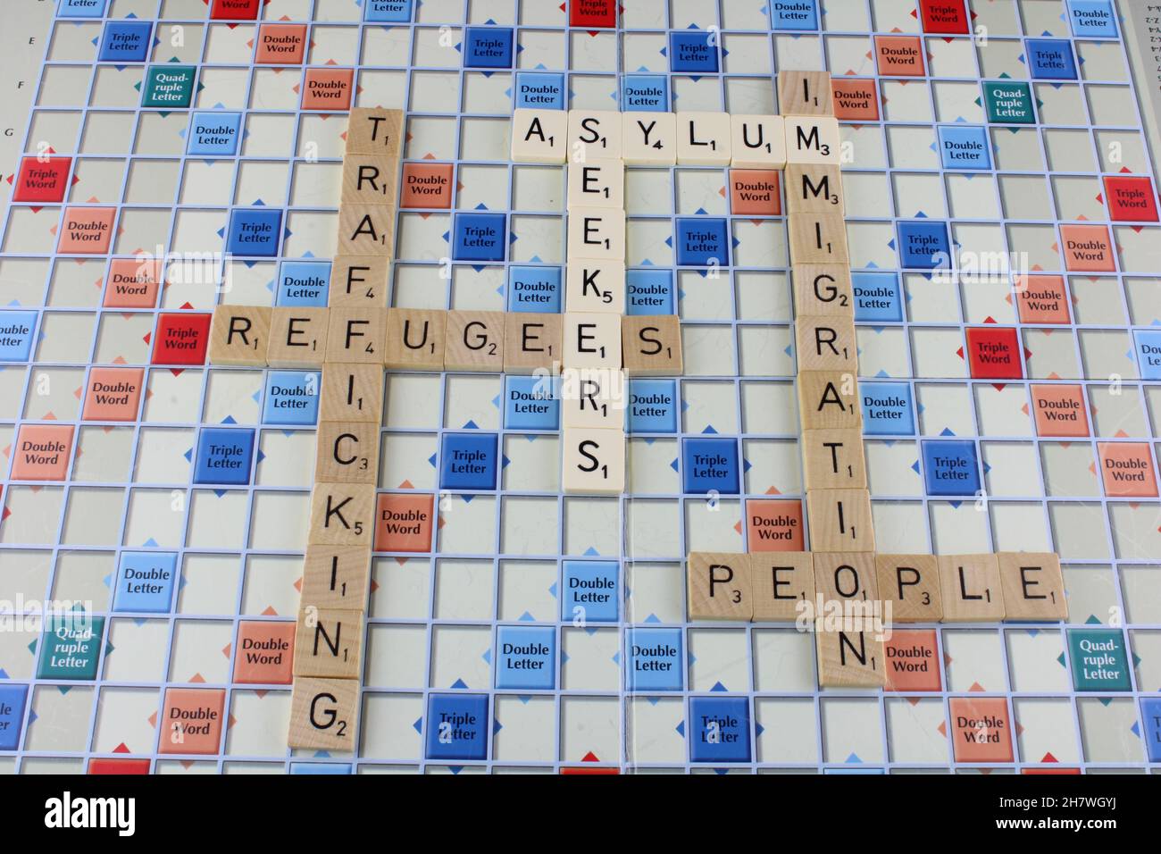 Asylum seekers, refugees, immigration and people trafficking on a scrabble board. With the words Asylum seekers in white for emphasis Stock Photo