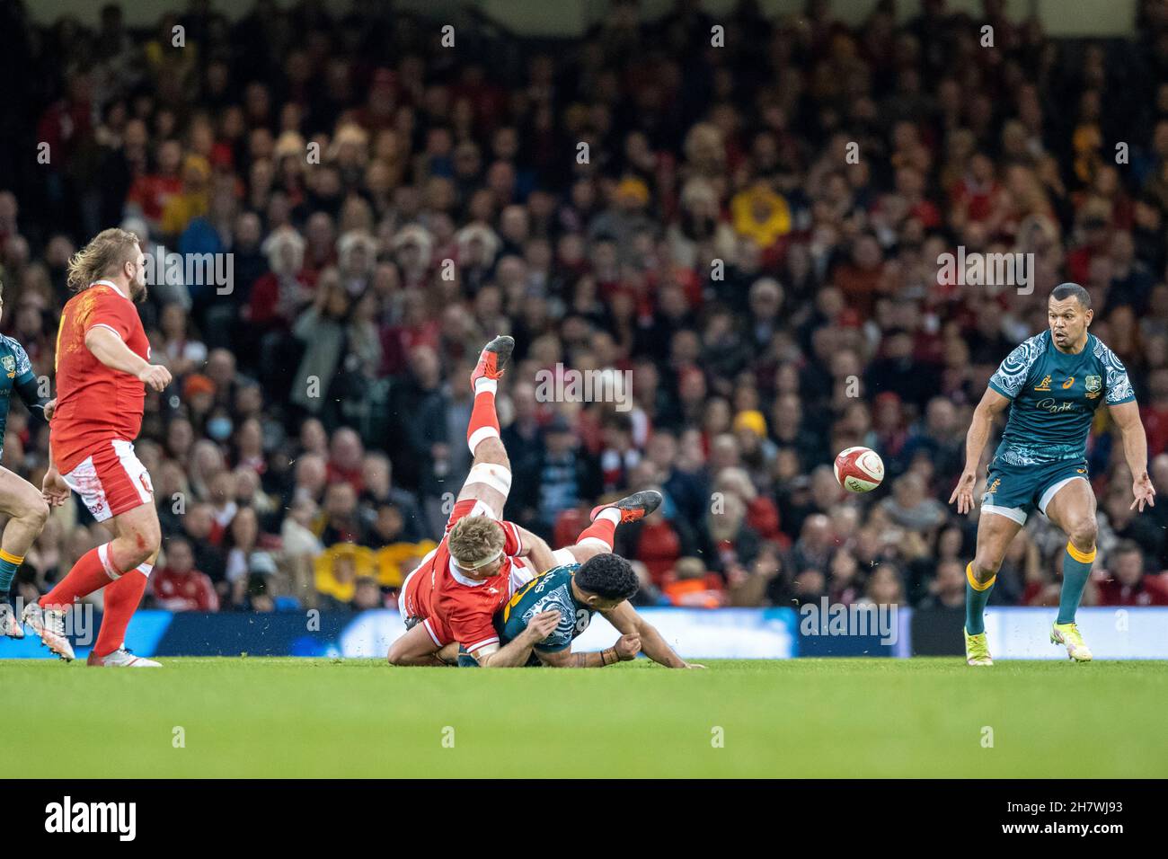 Australian inside centre, Hunter Paisami manages to slip a last minute pass to Kurtley Beale, after being tackled by Welshman, Aaron Wainwright. Stock Photo