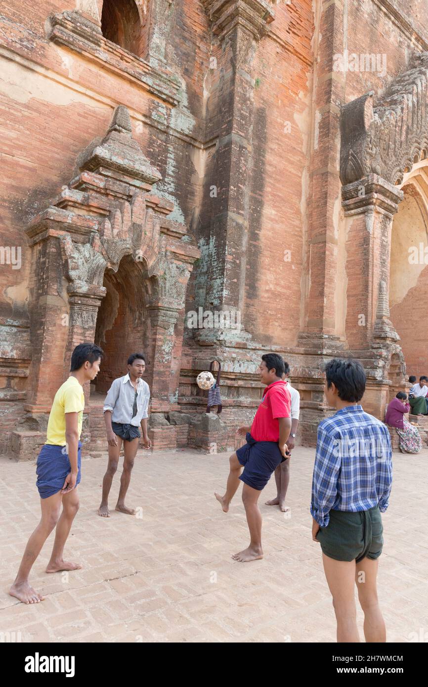 Young men playing Chinlone outside Dhammayangyi Temple. Stock Photo