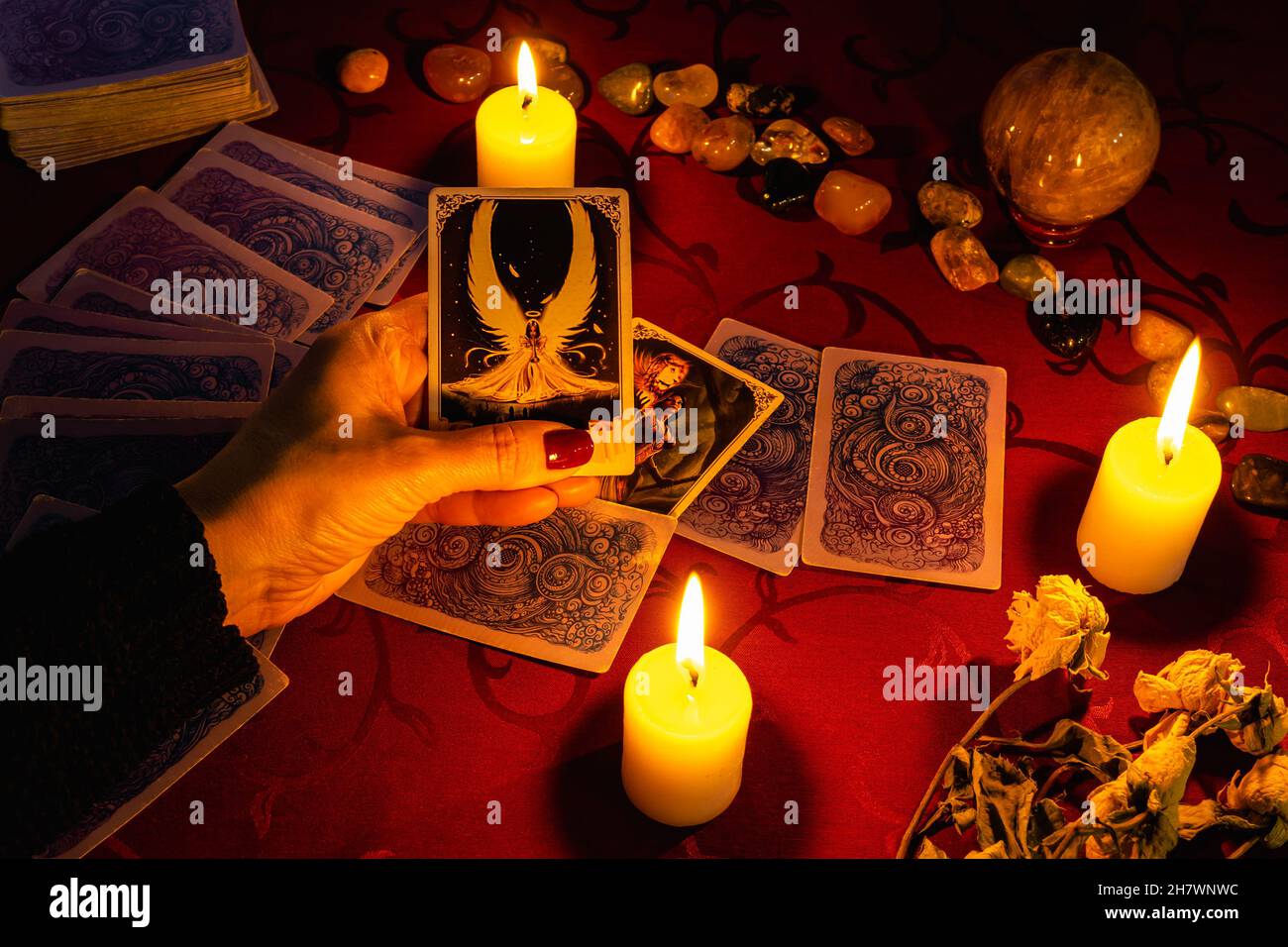 MINSK, BELARUS - November 2021: A fortune teller reads tarot cards and holds a justice card in her hand. Magic and occultism. Stock Photo
