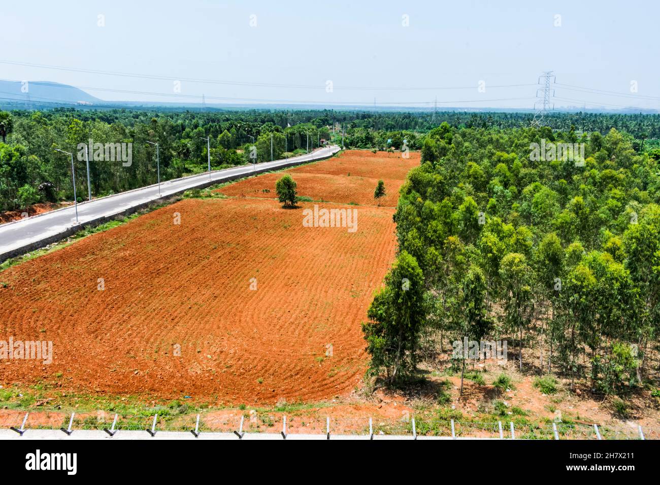 Road side red soil farm ready for paddy seeding by a tractor in a pattern looking a patterns