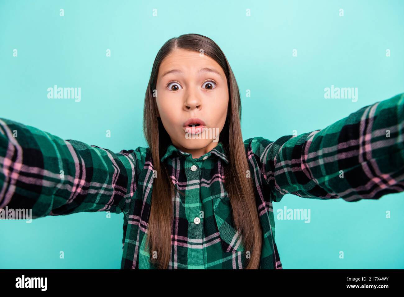 Photo of impressed funky school girl dressed checkered clothes big eyes tacking selfie isolated teal color background Stock Photo