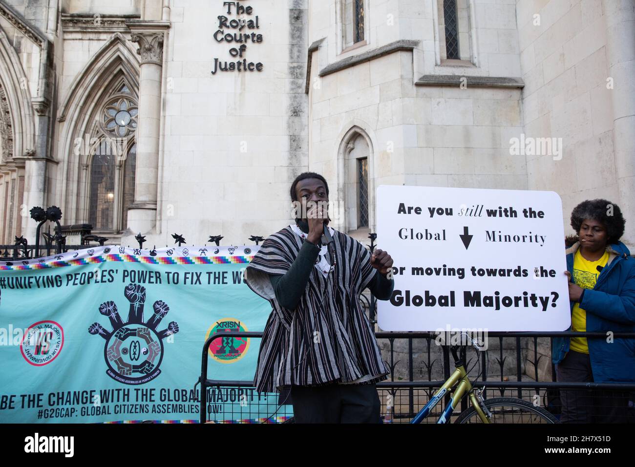 London, UK. 25th November, 2021. Jerry Amokwandoh addresses climate  activists outside the Royal Courts of Justice before an appeal on behalf of  Plan B.Earth, Tim Crosland and three young British citizens (Marina