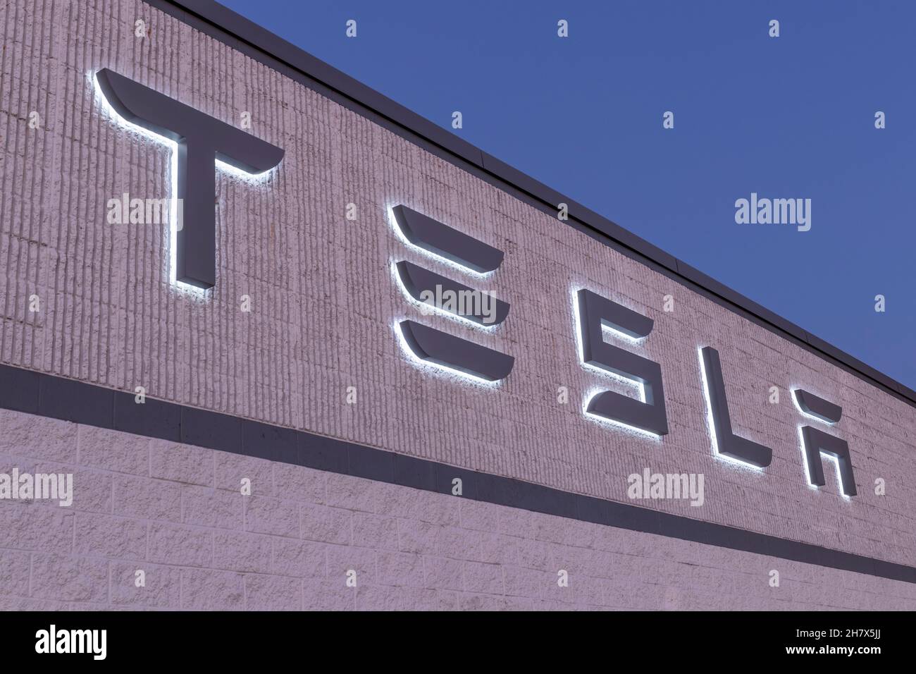 Indianapolis - Circa November 2021: Tesla electric vehicles logo. Tesla products include electric cars, battery energy storage and solar panels. Stock Photo