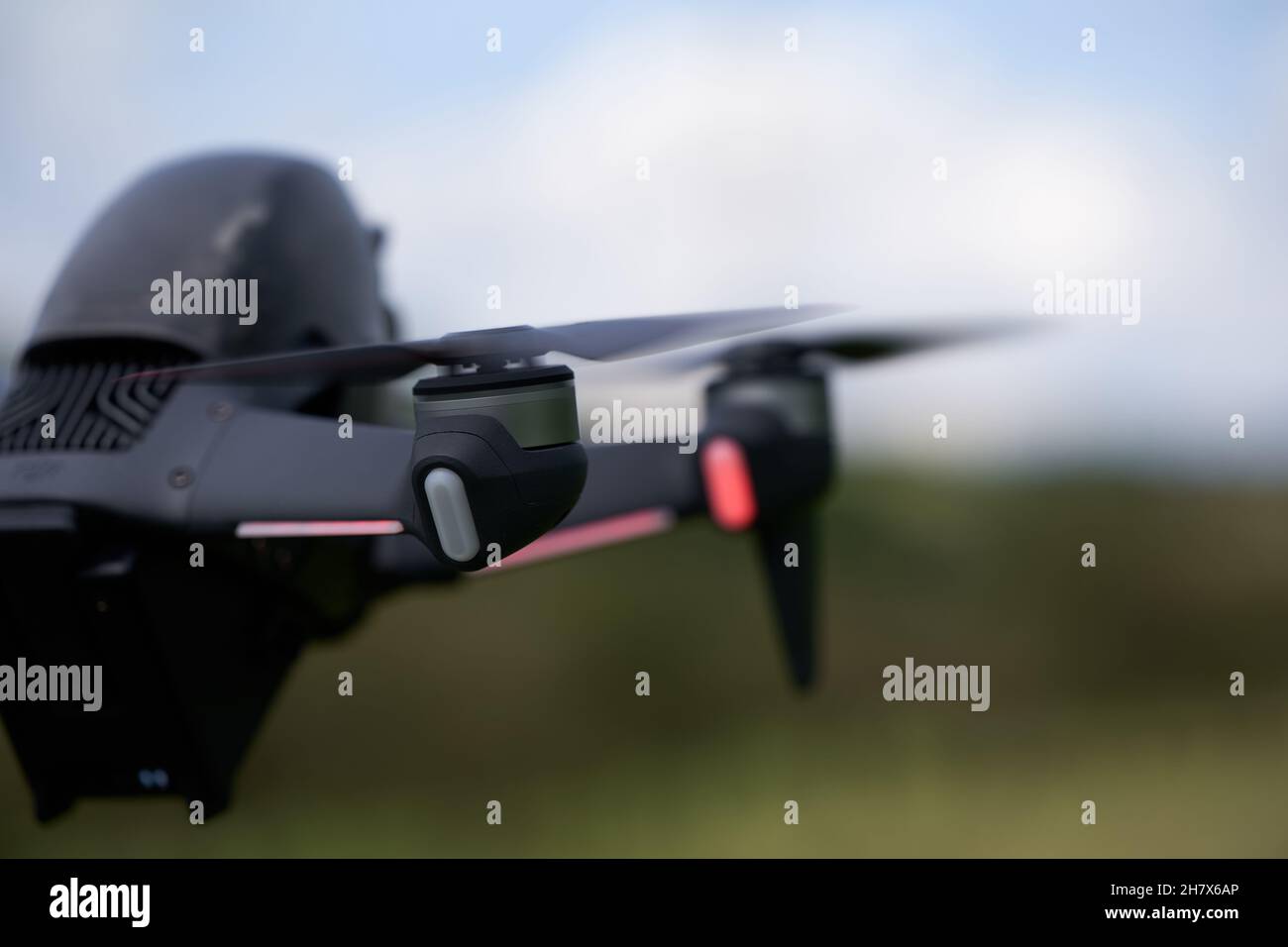 Nürtingen, Germany - June 26, 2021: Part of the dji fpv drone. Motor an black propellers from the newest uas. Meadow and sky depth of field. Rear view Stock Photo