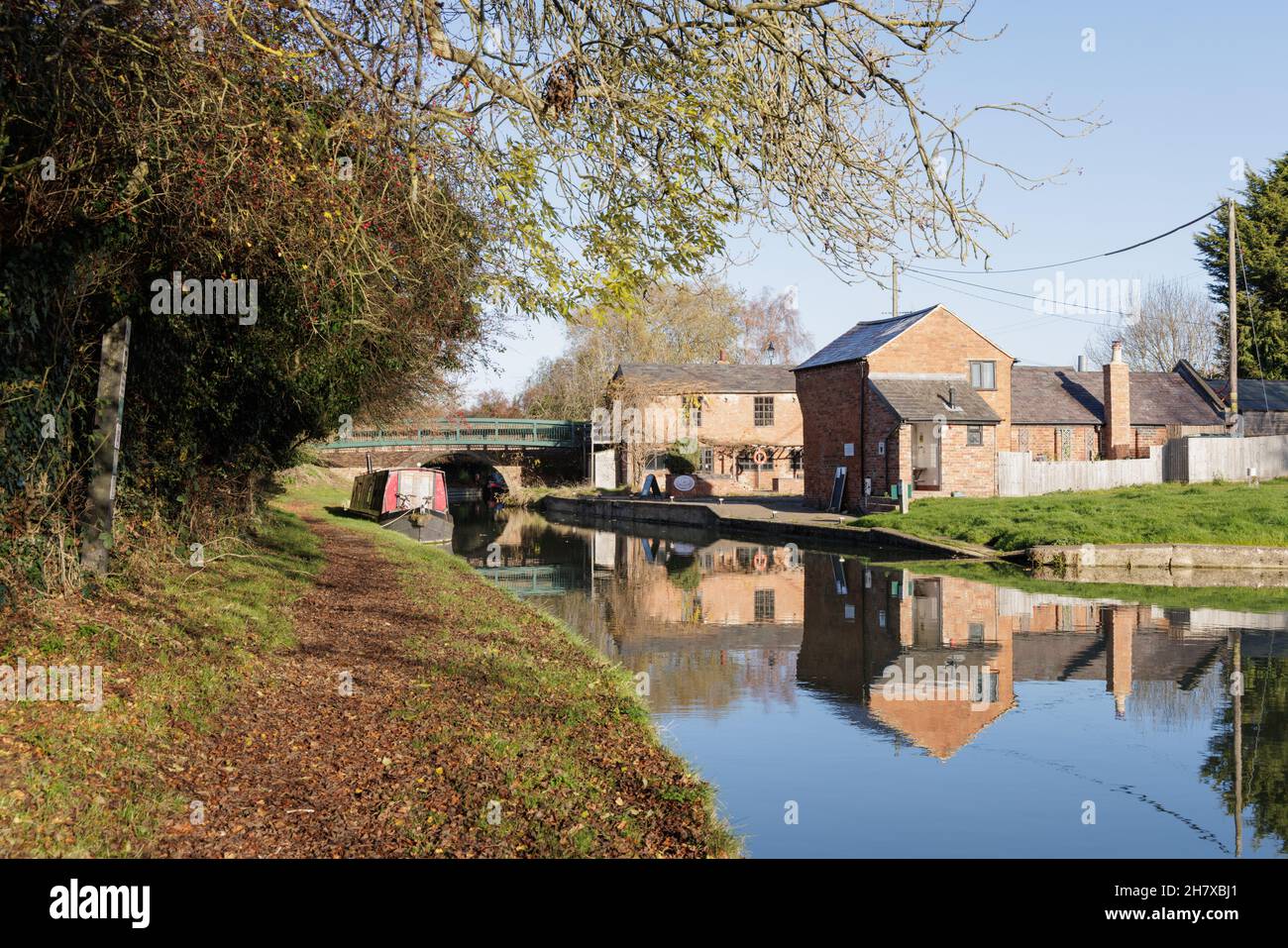 Crick, Northamptonshire, UK, November 26th 2021: In autumn the historic buildings at Crick Wharf are reflected in the water of the Grand Union Canal. Stock Photo