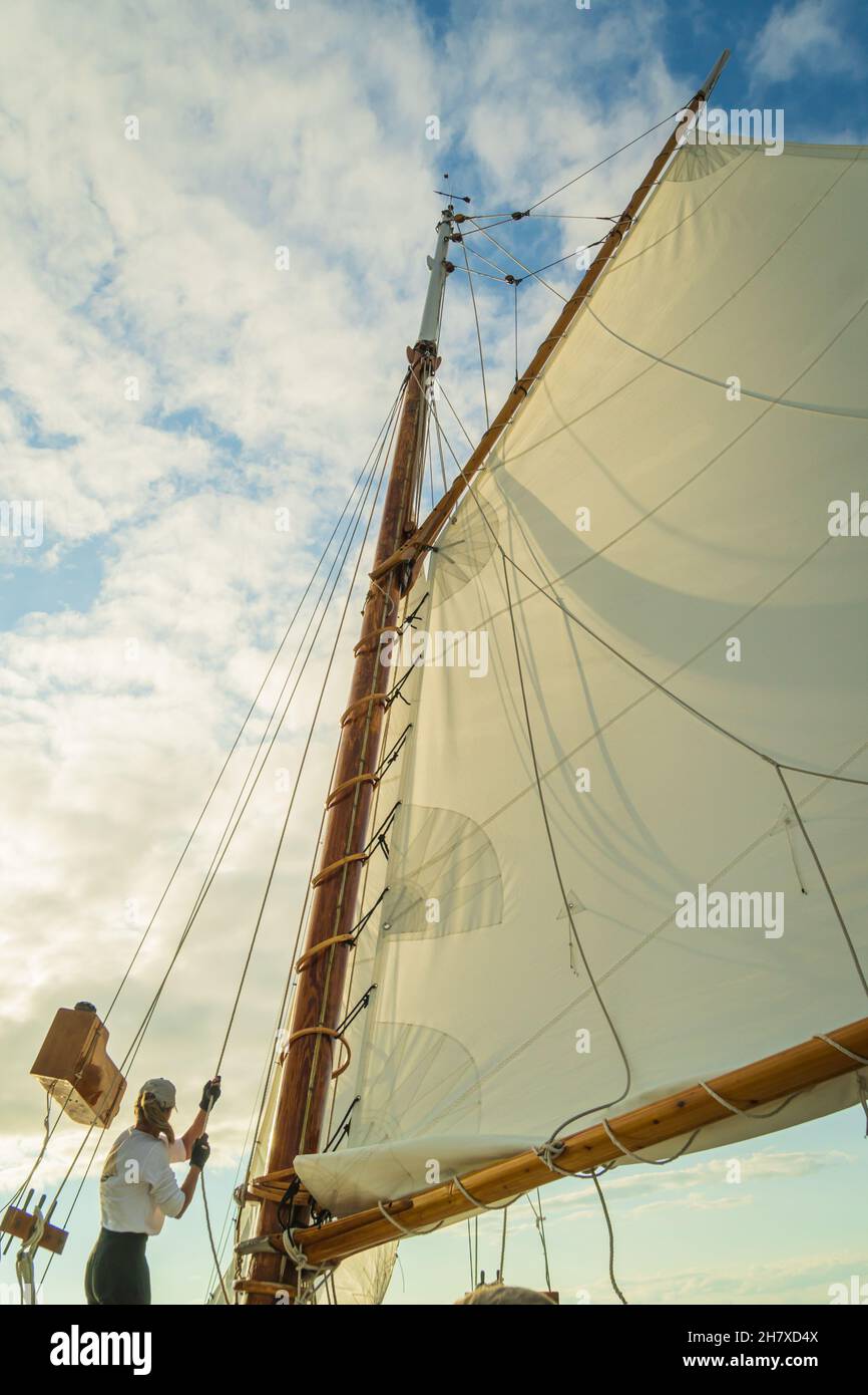 raising the sail on a historic  gaff-rigged 'Friendship' sloop Stock Photo