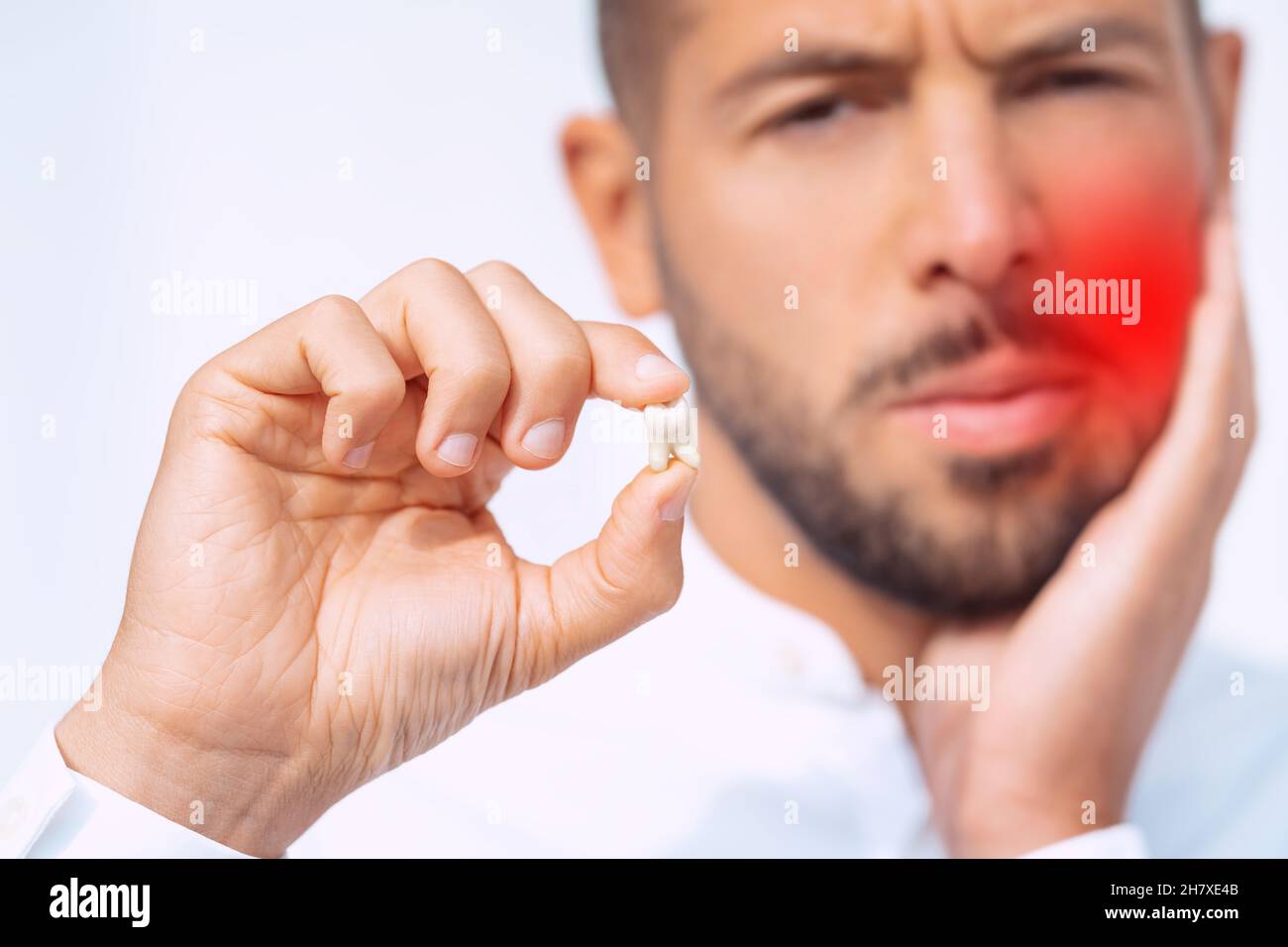 Man feeling pain after tooth extraction or tooth removal surgery Stock