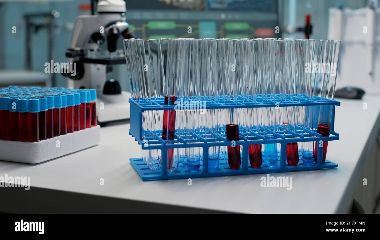 Close up of laboratory test tubes with blood on desk at workplace ...