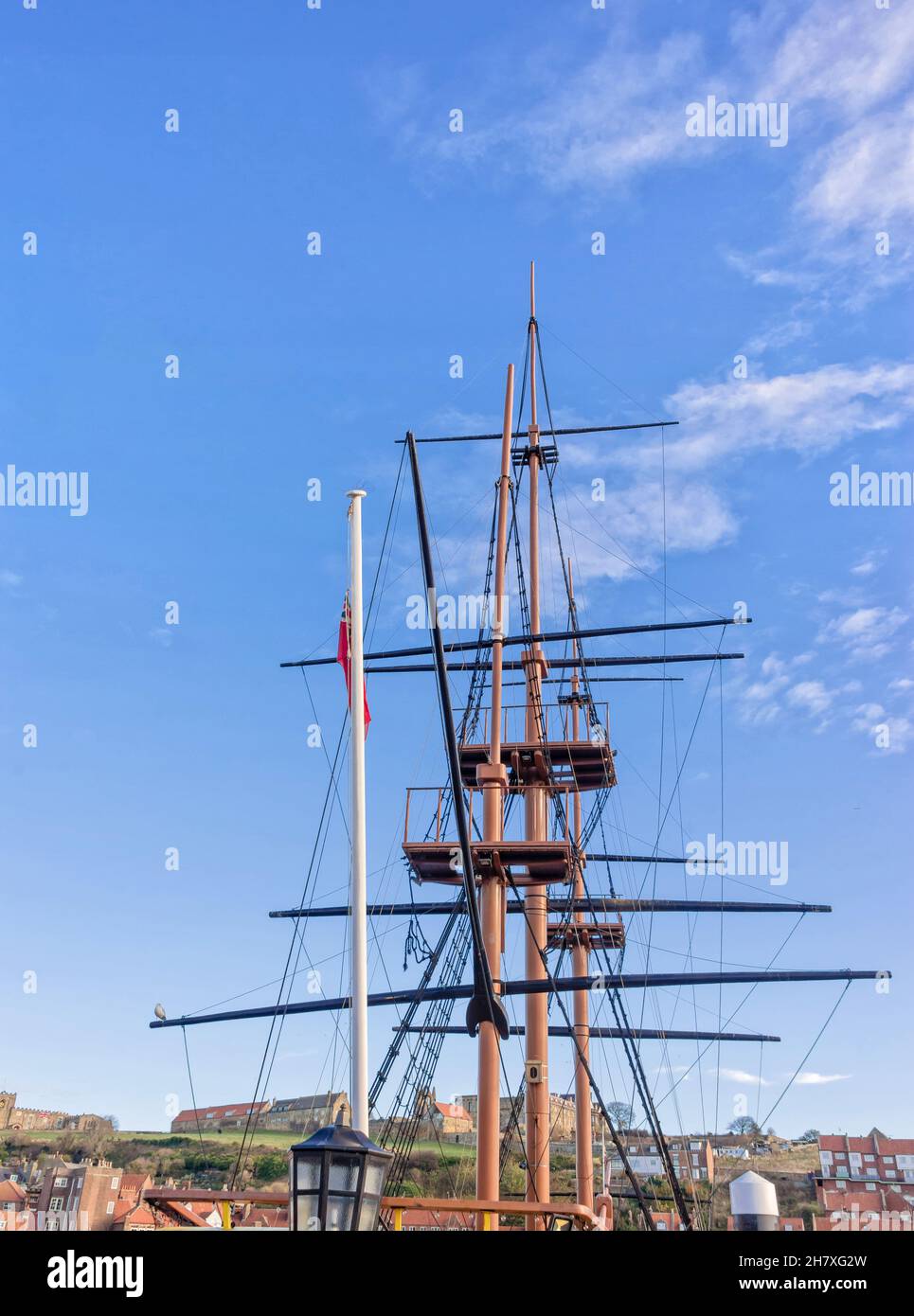The masts of a tall ship, shot from low angle, against a sky with light ...