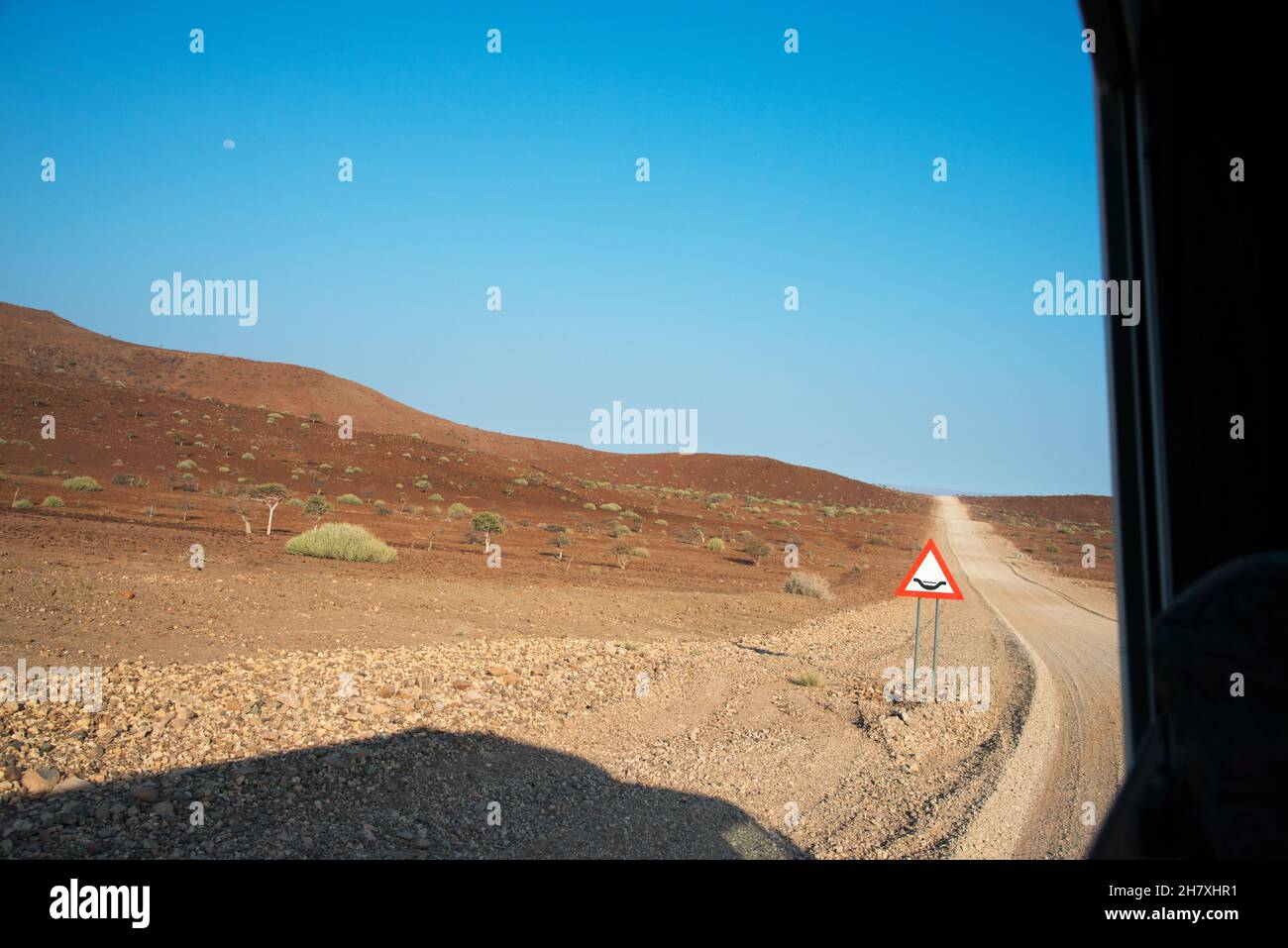 Arid landscape in Damaraland, Namibia. Bumpy road ahead and warning sign. Africa Stock Photo