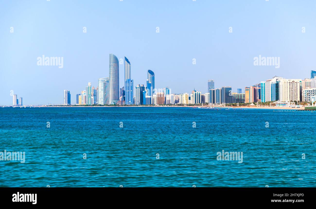Abu Dhabi coastal cityscape with tall skyscrapers towers under clear blue sky on a daytime Stock Photo
