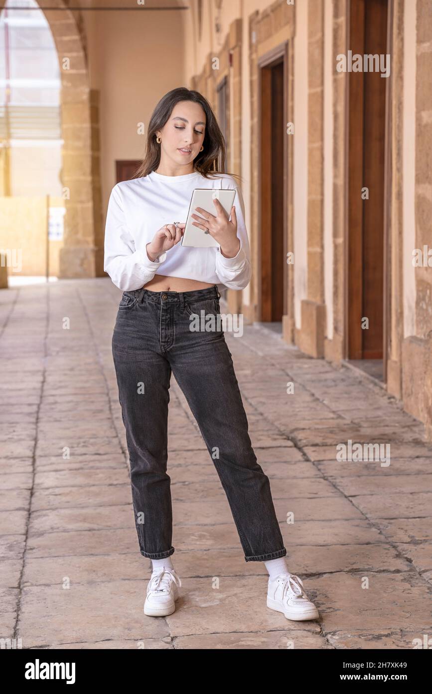 young woman of generation x uses tablet device in a Sicilian town Stock Photo