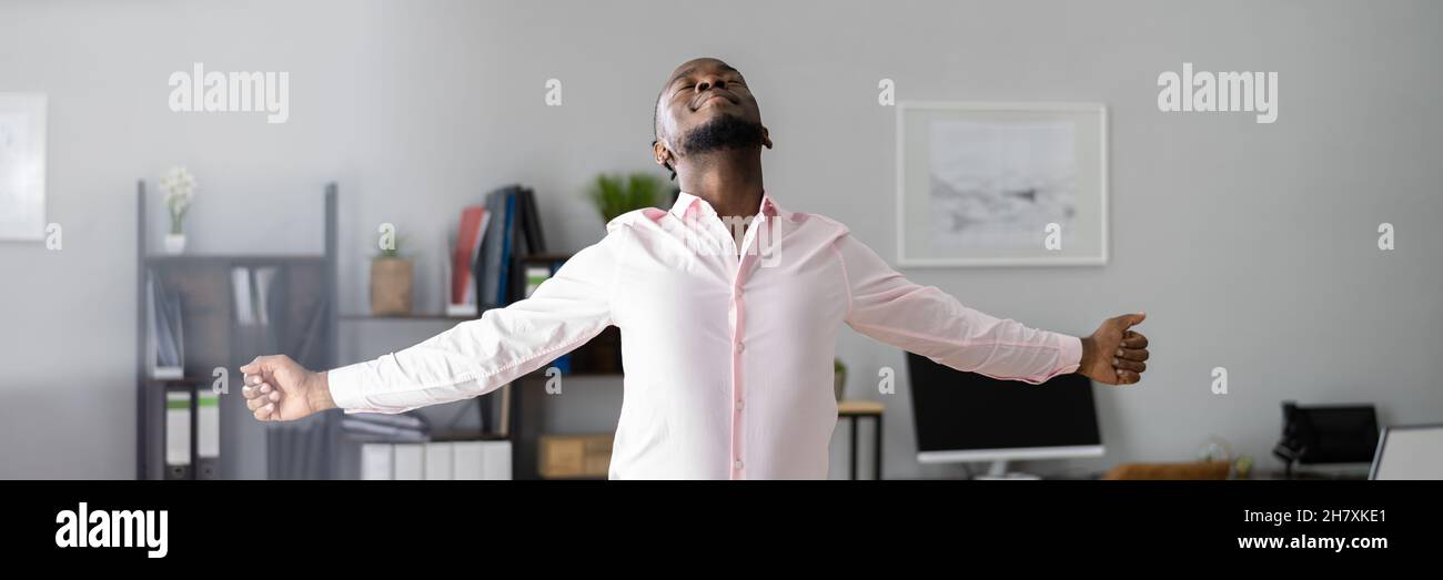 Man Doing Stretch Exercise At Work In Office Stock Photo