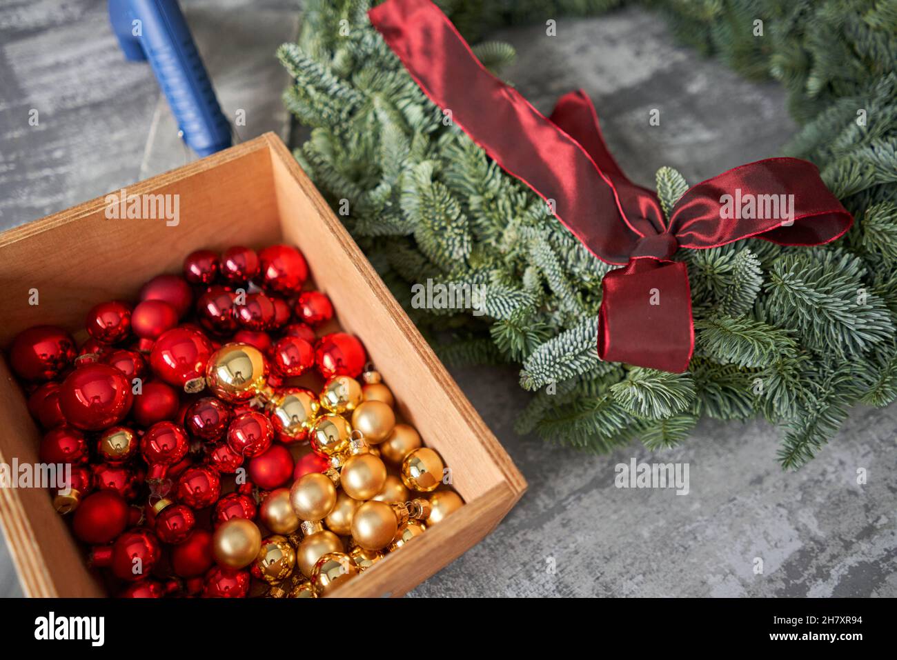 Manufacturer of Christmas wreath from branches of pine for holiday. Master class on making decorative ornaments. Christmas decor with their own hands. Stock Photo