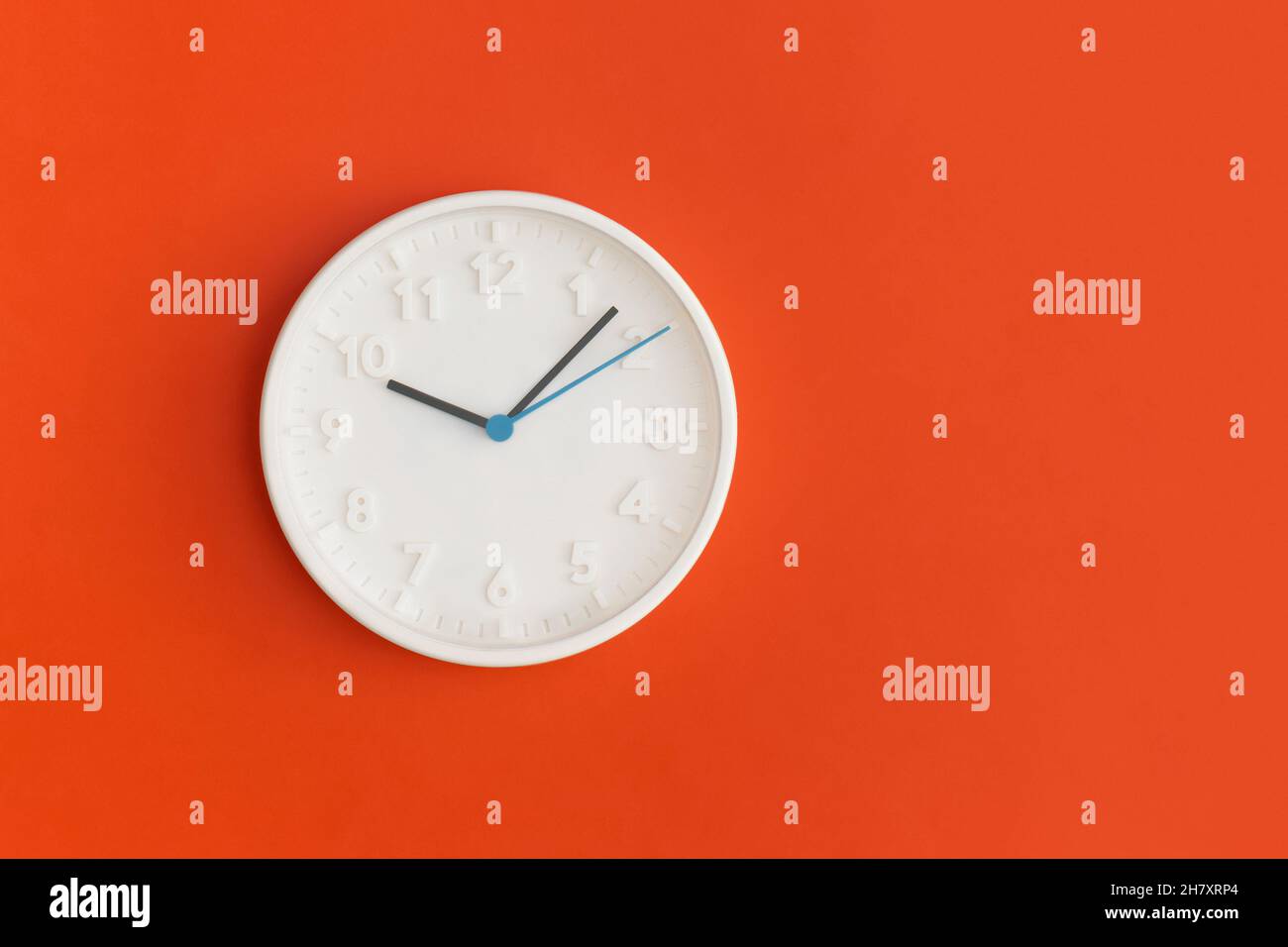 White wall Clock on red background. Stock Photo
