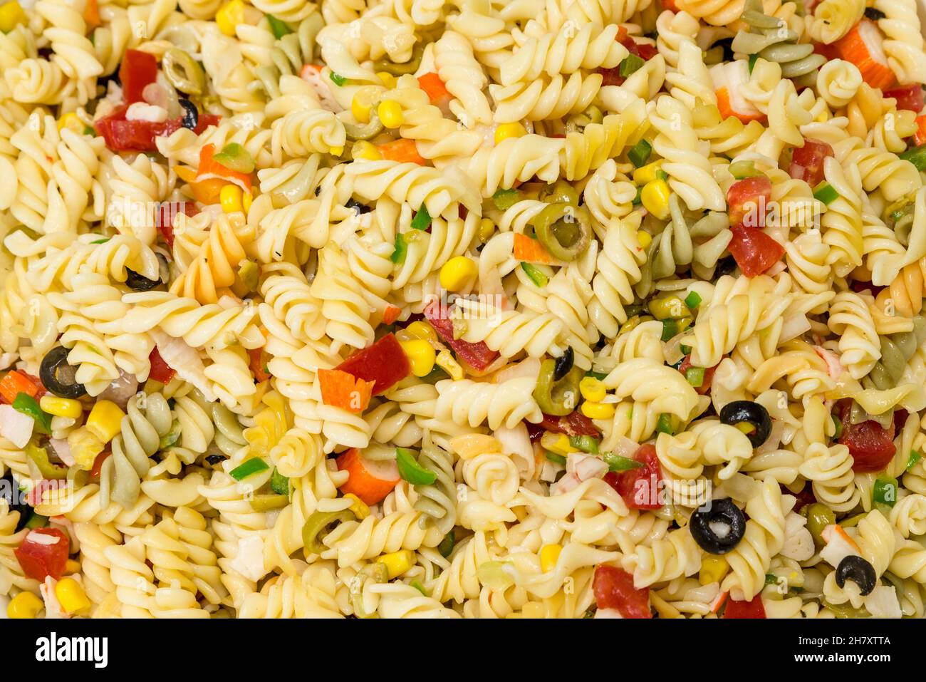 Pasta salad background with black olives, corn, peppers and surimi Stock Photo