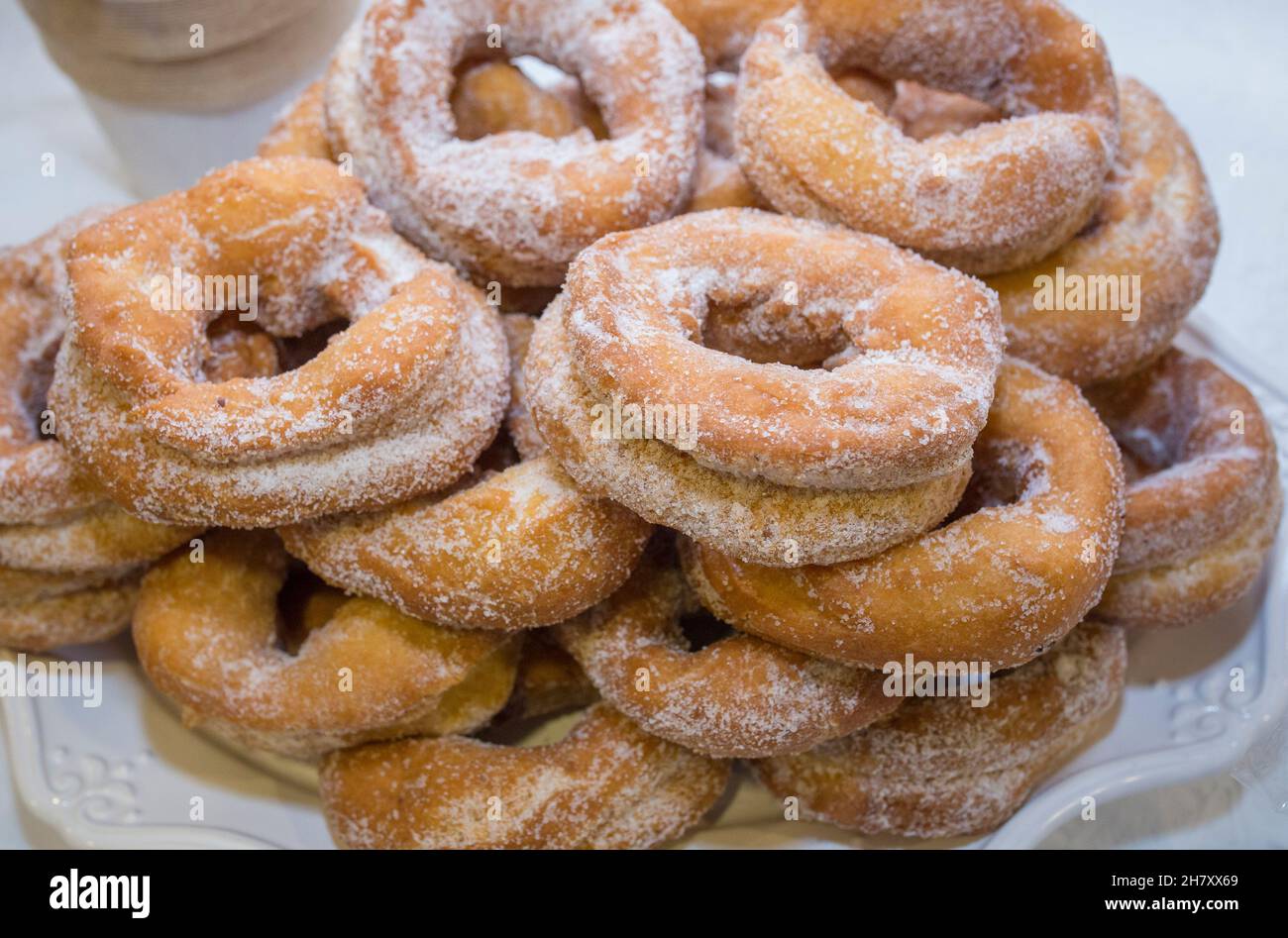 Spanish fritter donuts or roscas fritas. Dusted with sugar and plated in porcelain dish Stock Photo