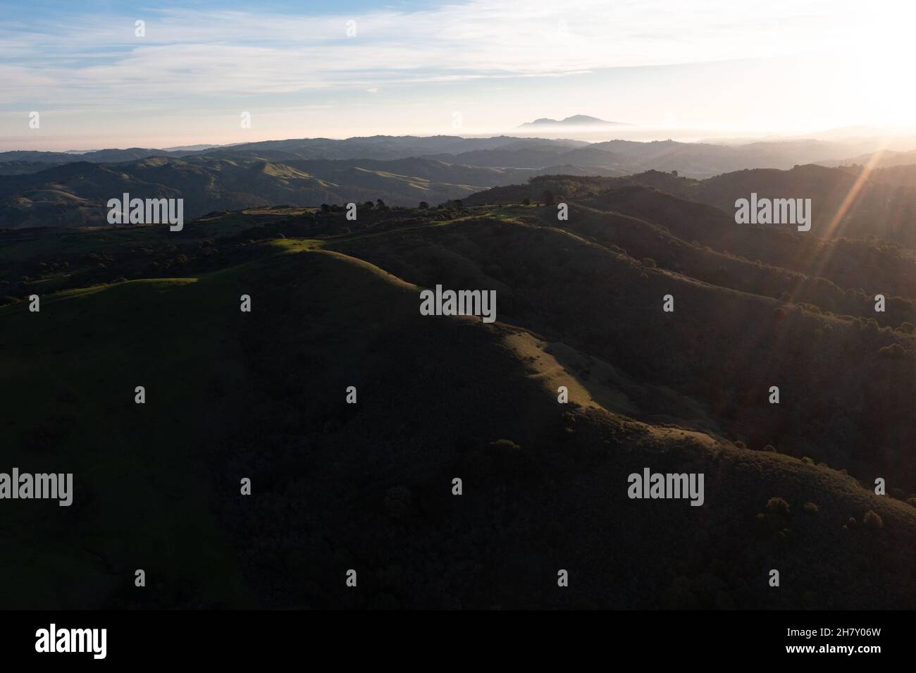 Early morning sunlight shines on the green hills of the east bay, near San Francisco Bay. These hills in California turn green during winter months. Stock Photo