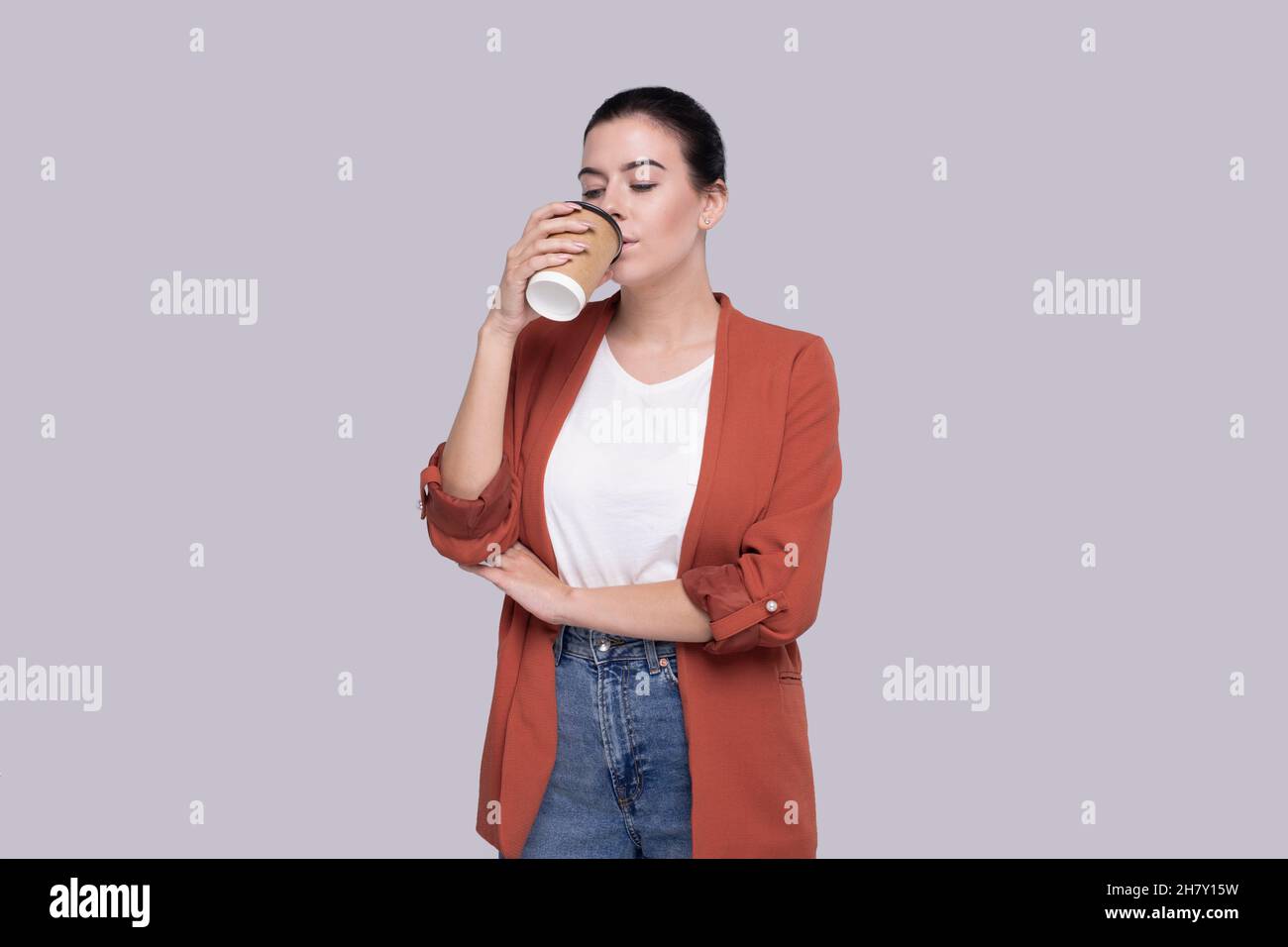 Girl Drinking Coffee from Take Away Cup. Girl With To Go Coffee Cup in Hands. Stock Photo