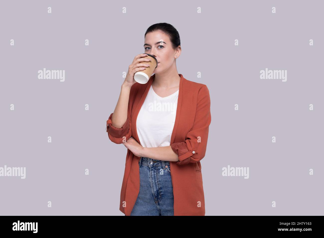 Girl Drinking Coffee from Take Away Cup. Girl With To Go Coffee Cup in Hands. Stock Photo