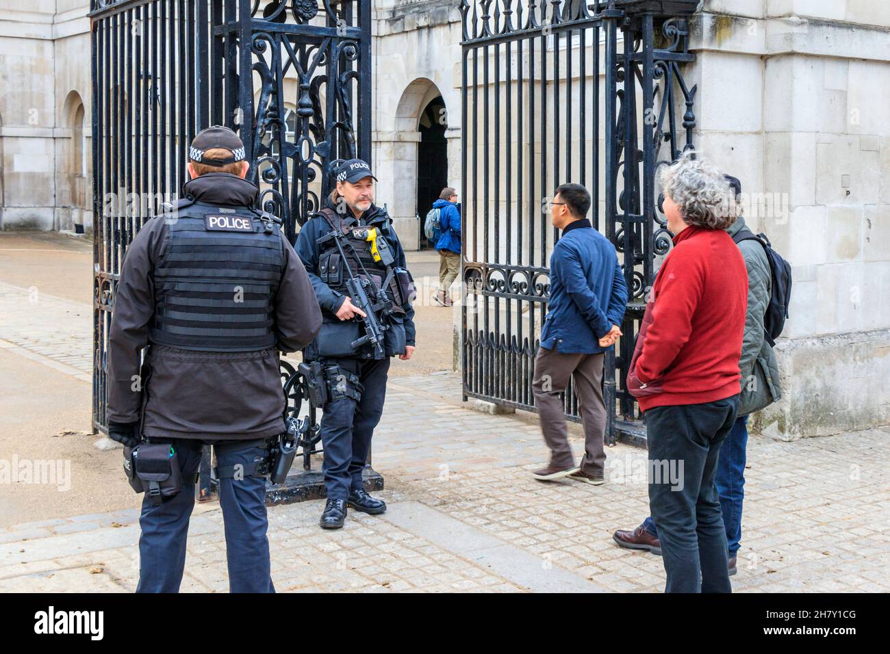 Tourists chat to armed police at the gates of Horseguards, Whitehall, London, UK Stock Photo