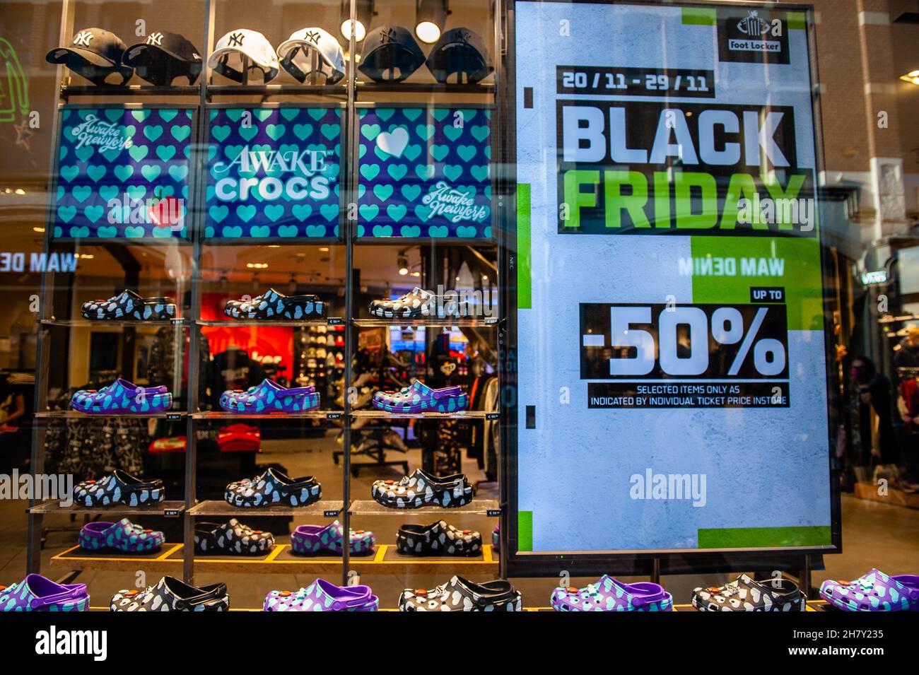 Amsterdam, Netherlands. 25th Nov, 2021. A poster offering discounts is seen  placed close to a group of Crocs shoes in Kavelstraat ahead of Black Friday  with the shopping centre looking emptier compared