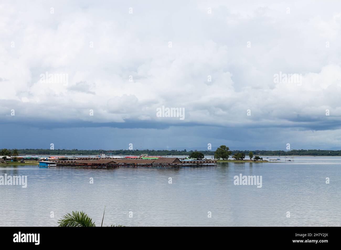 The beach and the water pavilion seen from far away. showing black rain clouds Stock Photo