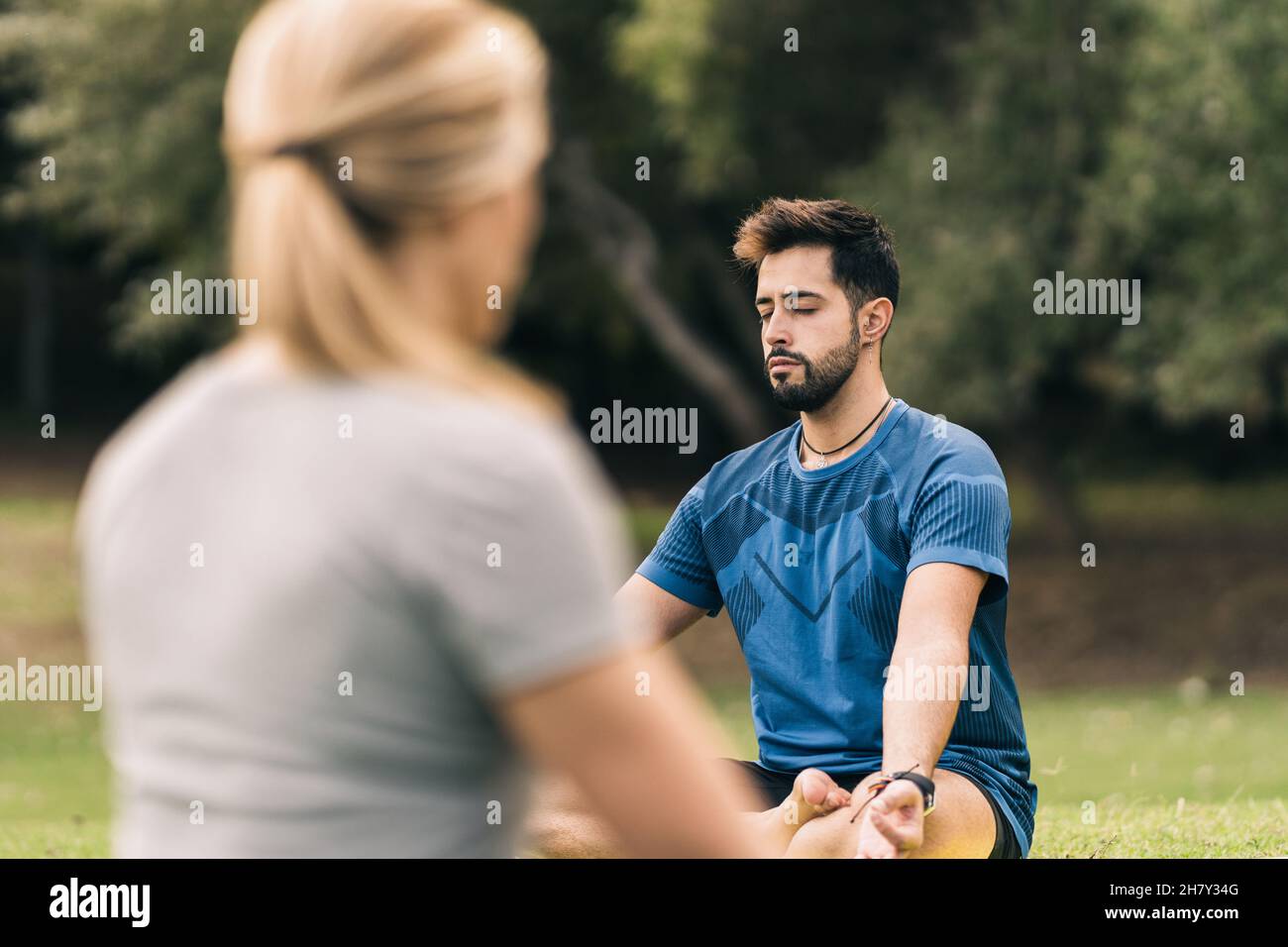 Learner and instructor doing yoga in a park Stock Photo