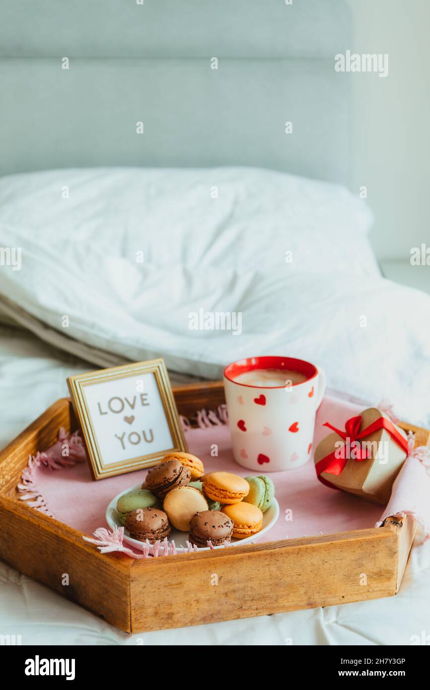 https://c8.alamy.com/comp/2H7Y3GP/valentines-day-breakfast-in-bed-for-lover-love-you-card-in-the-frame-a-cup-of-coffee-or-cocoa-macaroons-heart-shaped-gift-box-with-red-ribbon-on-2H7Y3GP.jpg