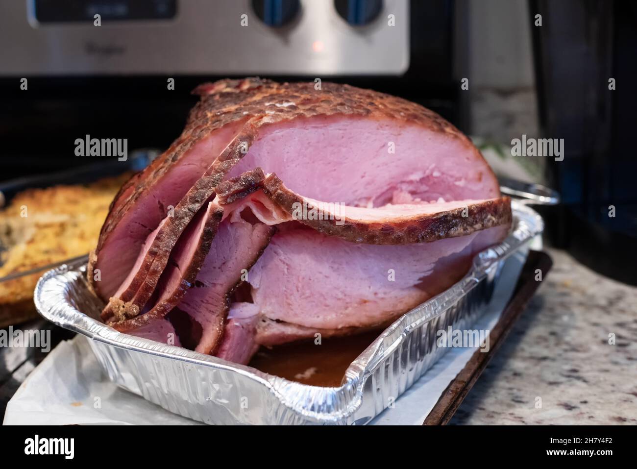 Sliced brown sugar ham hot from the oven is the perfect main course for holiday meals this autumn and winter. Stock Photo