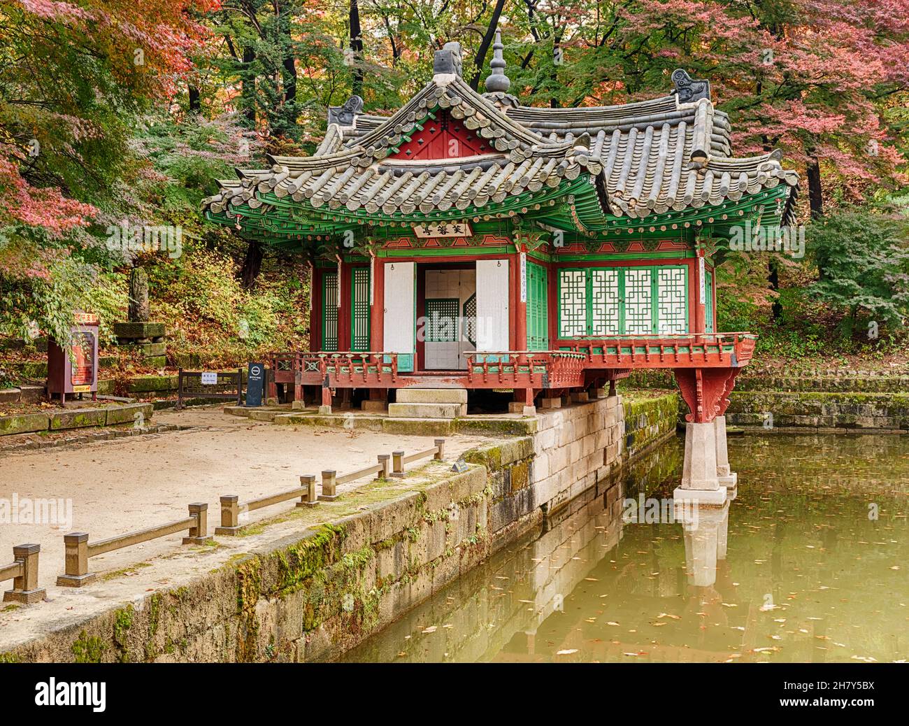 A gravelled path leads to a small villa by the side of a pond in the secret garden of the Changdeokgung royal palace in Seoul. Stock Photo