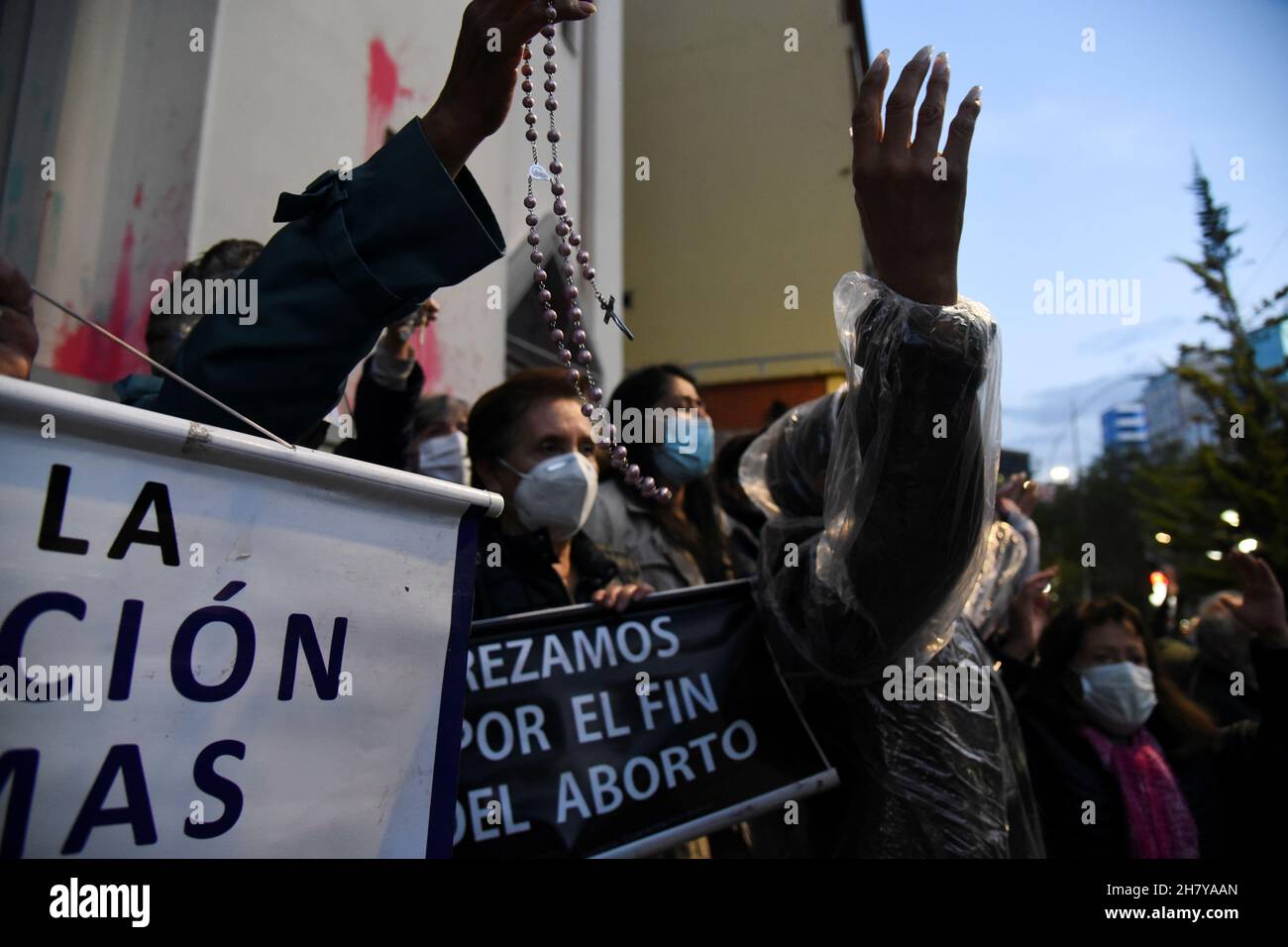 Church members, including one holding a sign reading 'We pray for the end of abortion', stand in front of a church during a protest on International Day for the Elimination of Violence Against Women, in La Paz, Bolivia November 25, 2021. REUTERS/Claudia Morales Stock Photo