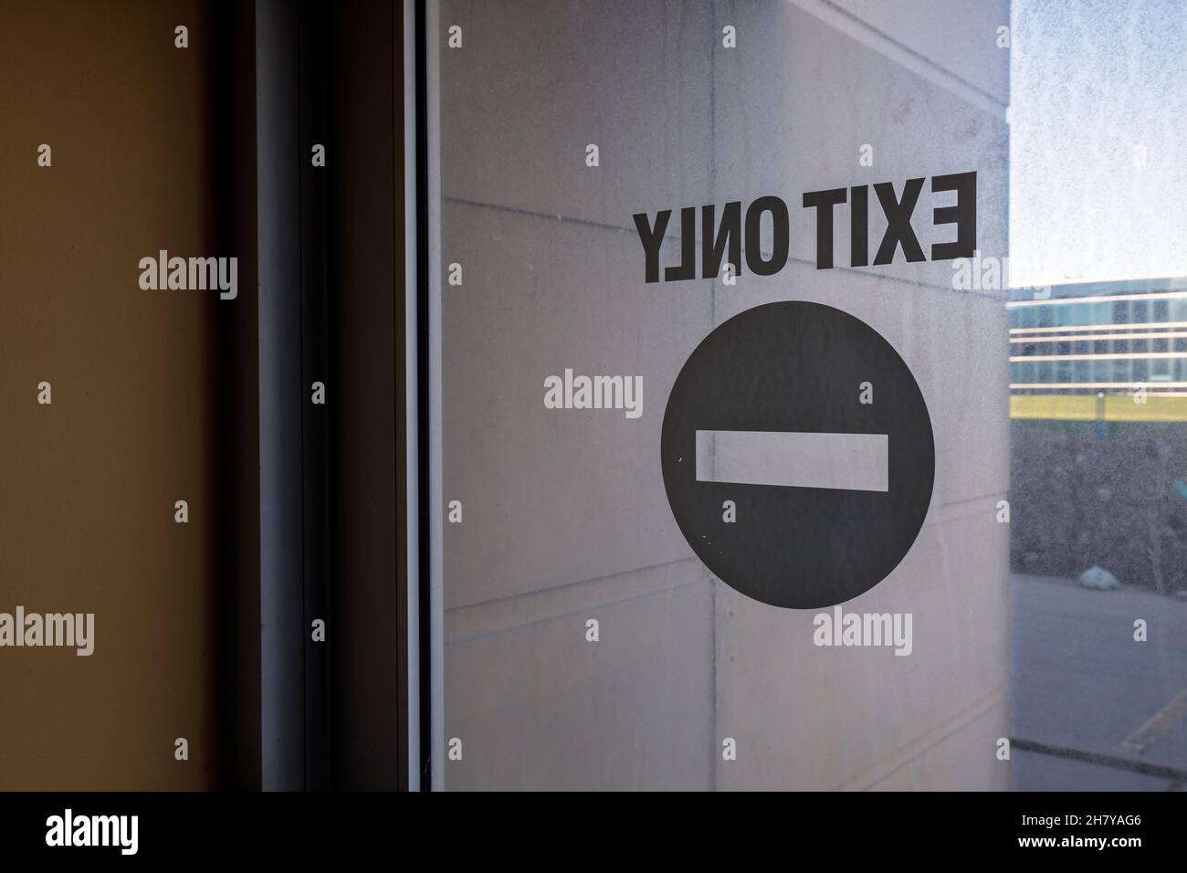 An exit only sign on a glass door.  This building has since been demolished. Stock Photo