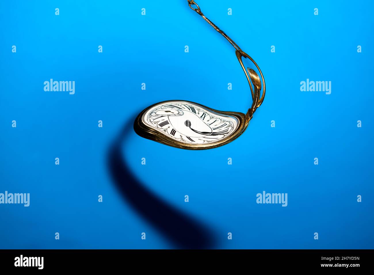 Warped, Spiraling Clock face on blue background Stock Photo