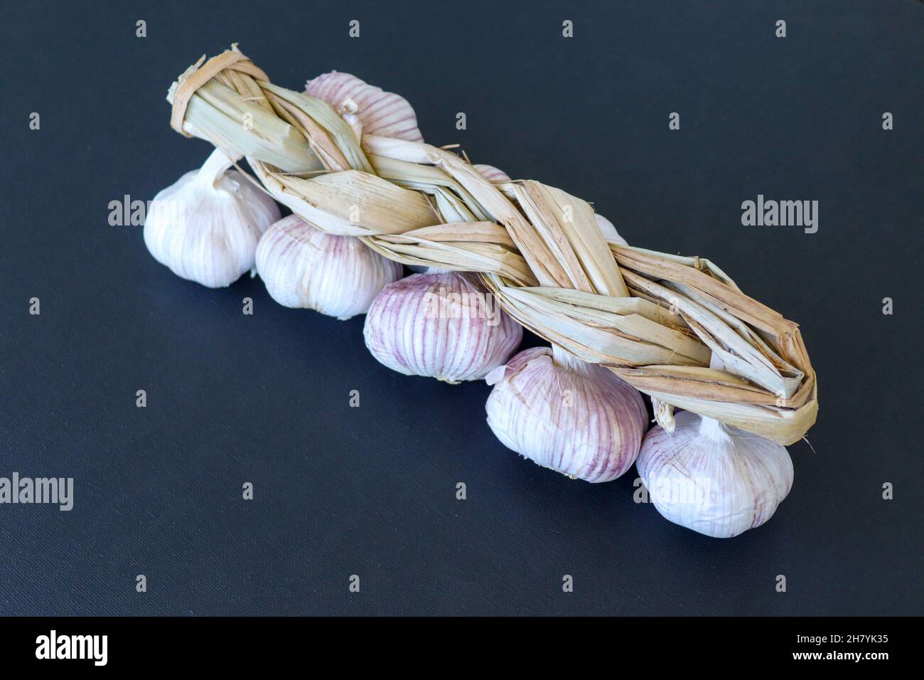 Garlic braid against black background Stock Photo