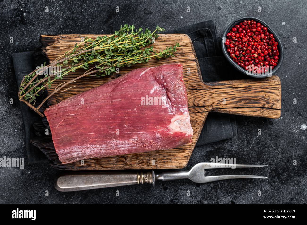 Raw Beef Tenderloin fillet meat on butcher wooden board. Black ...
