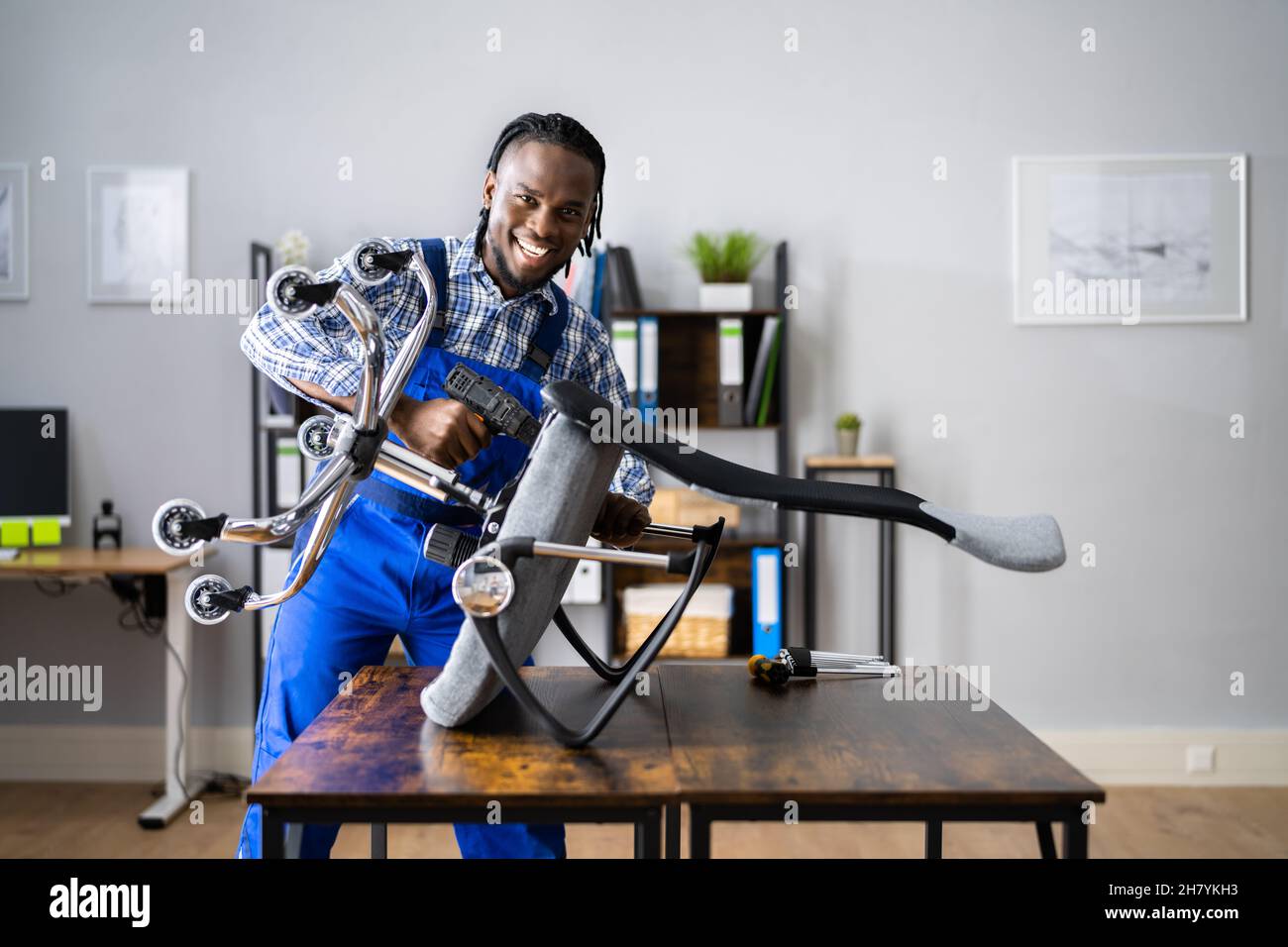 Office Chair Assembling And Repair. Man Working With Tool Stock Photo