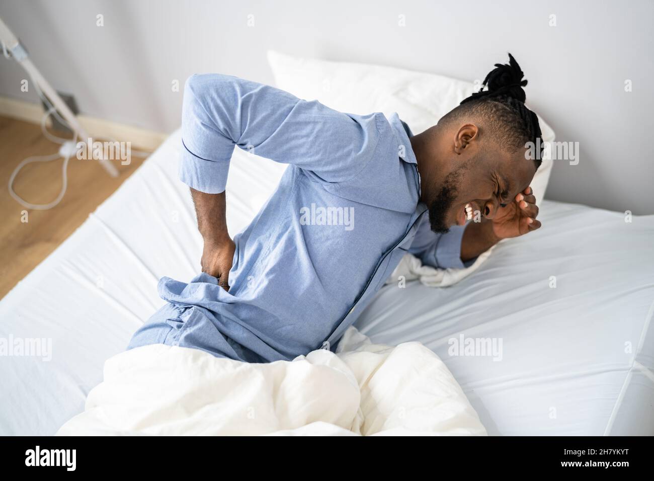 Man Suffering From Back Pain Sitting On Bed Stock Photo - Alamy