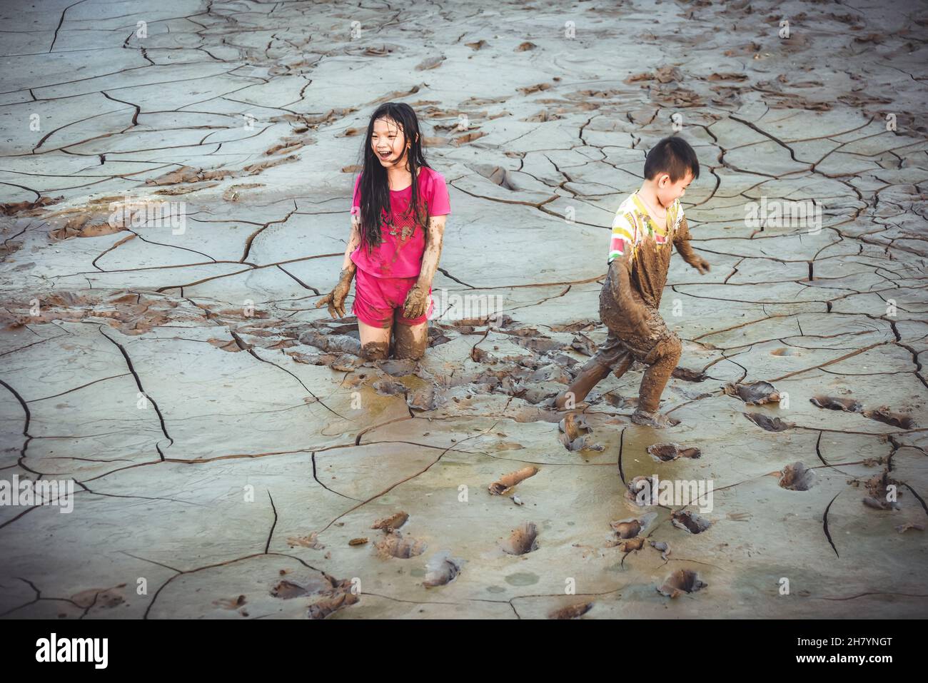 Children are playing in the mud during the quarantine days during the covid-19 pandemic when all activities are suspended for entertainment Stock Photo