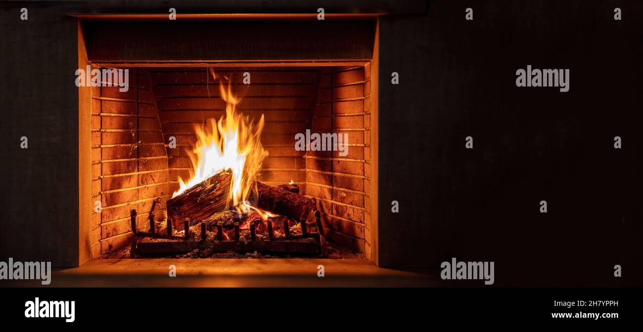 Fireplace burning firewood. Fire flames on wood logs, black background